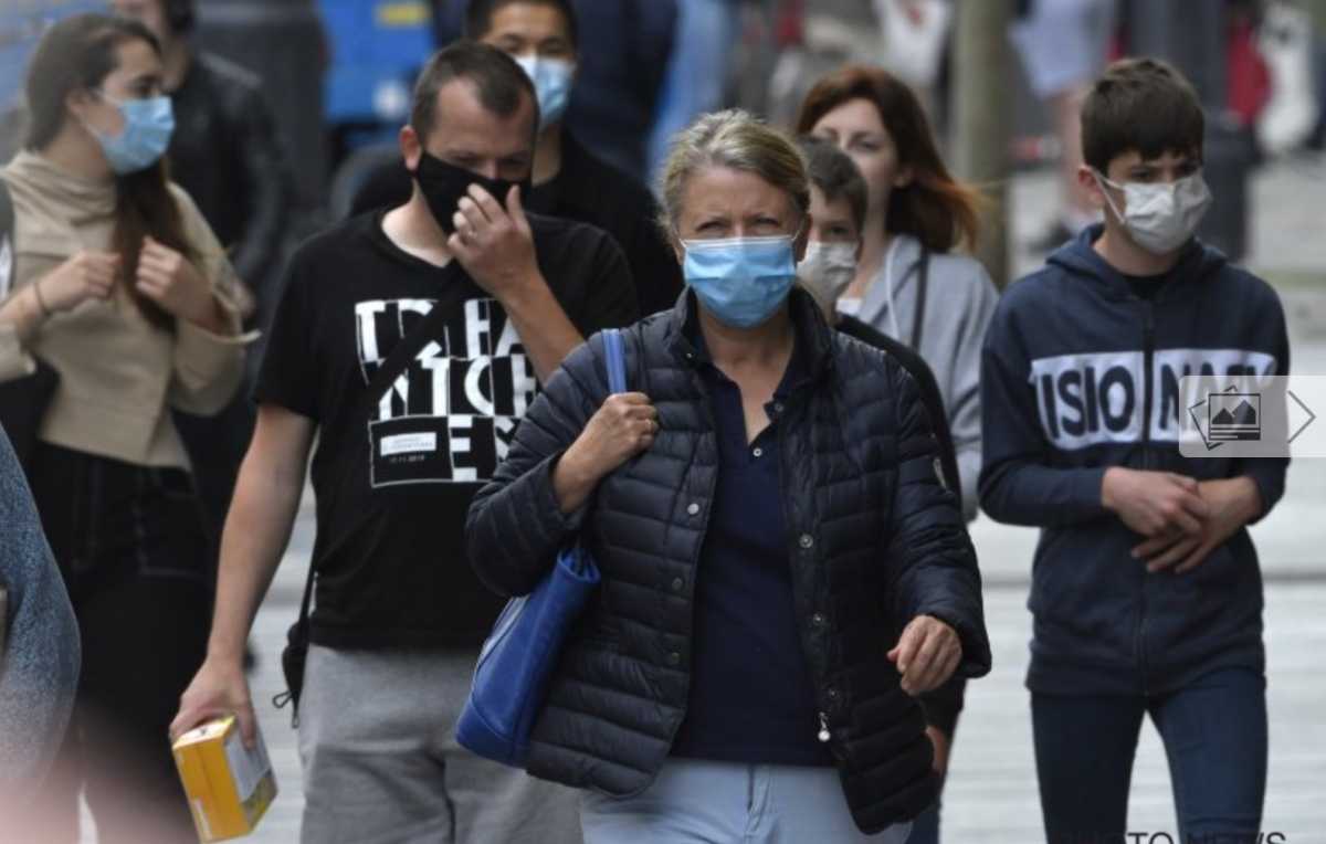 Mensen dragen mondmaskers op straat