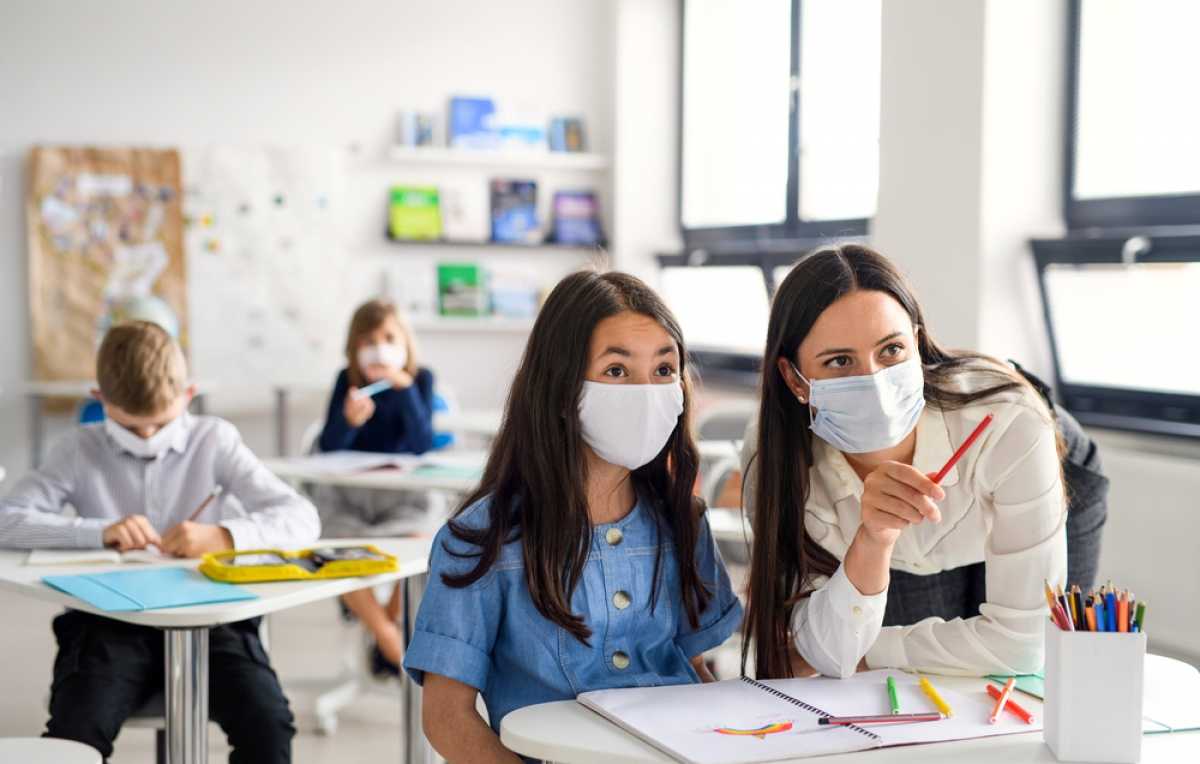 leerkracht en leerling met mondmasker